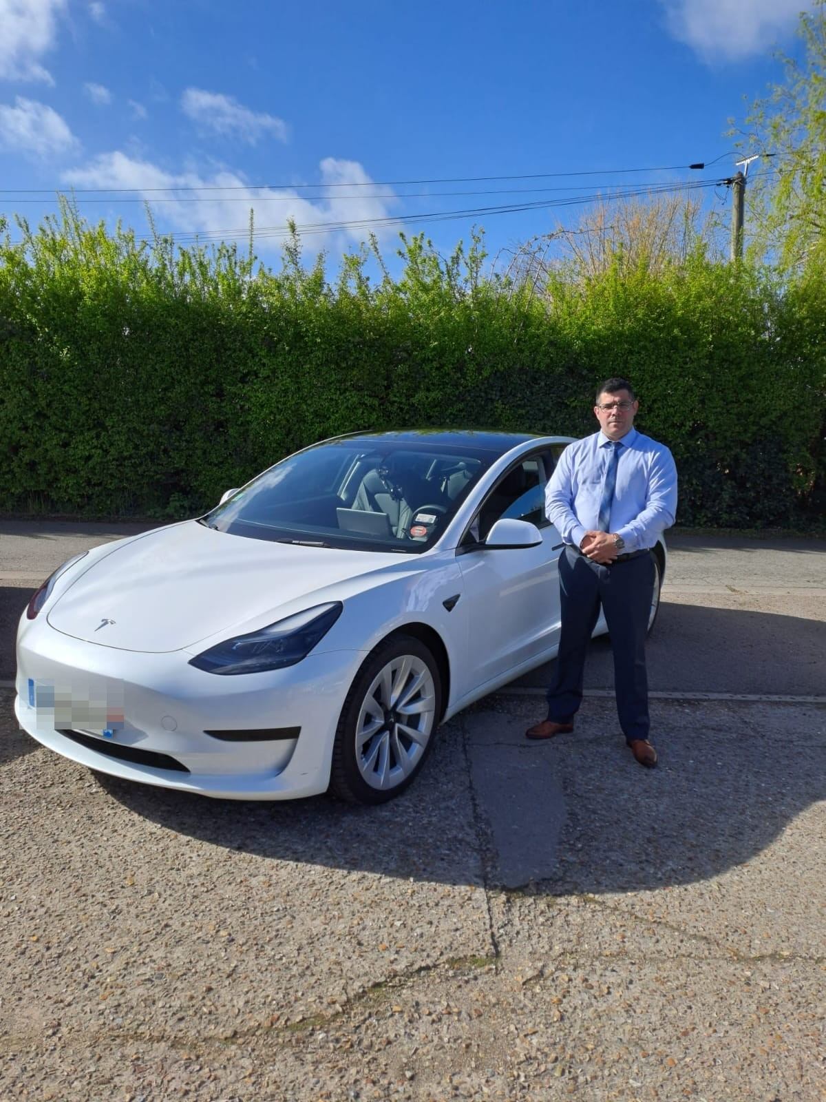 David, chauffeur privé VTC dans les Yvelines, devant sa berline électrique
